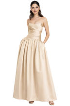 Woman wearing a gold strapless gown on a white background