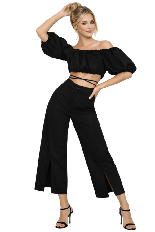 Woman wearing a black outfit with wide-leg pants and a top with puffed sleeves on a white background