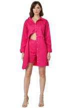 Woman wearing a bright pink outfit with a shirt and shorts on a white background