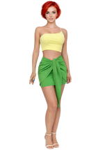 Woman wearing a yellow top and green skirt on a white background