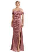 Woman wearing a pink strapless gown with a slit on a white background