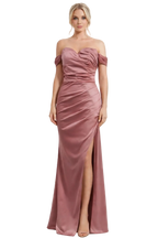 Woman wearing a pink strapless gown with a slit on a white background