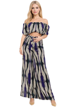 Woman wearing a patterned off-shoulder top and long skirt on a white background
