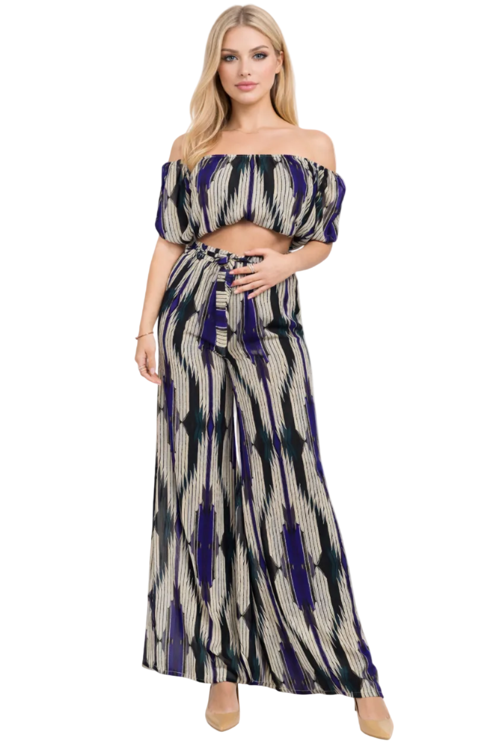 Woman wearing a patterned off-shoulder top and long skirt on a white background