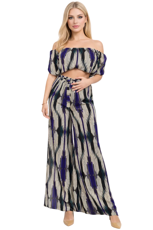 Woman wearing a patterned off-shoulder top and long skirt on a white background