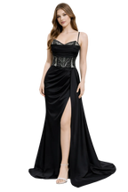 Woman wearing a black evening gown with a high slit on a white background