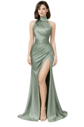 Woman wearing a green evening gown with a high slit on a white background