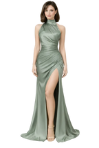 Woman wearing a green evening gown with a high slit on a white background