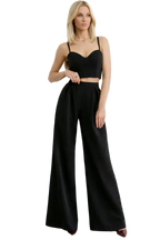 Woman wearing a black outfit with wide-leg pants on a white background