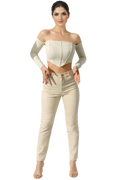 Woman wearing a white off-shoulder top and beige pants on a white background