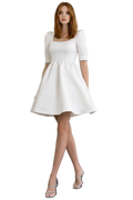 Woman wearing a white dress on a plain background