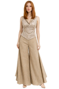 Woman wearing a beige sleeveless top and wide-leg pants on a white background