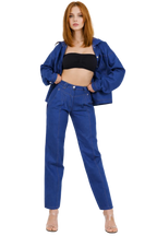 Woman wearing a blue denim outfit on a white background
