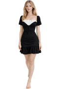 Woman wearing a black dress with white trim on a white background