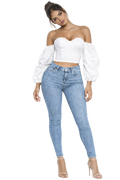 Woman wearing a white strapless top and light blue jeans on a white background