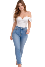 Woman wearing a white off-shoulder top and blue jeans on a white background